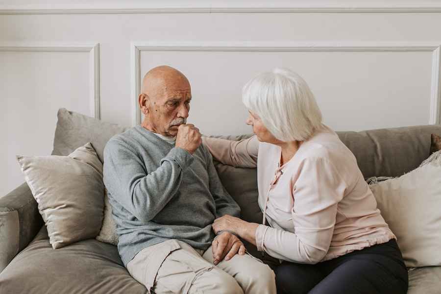 An elderly man coughing