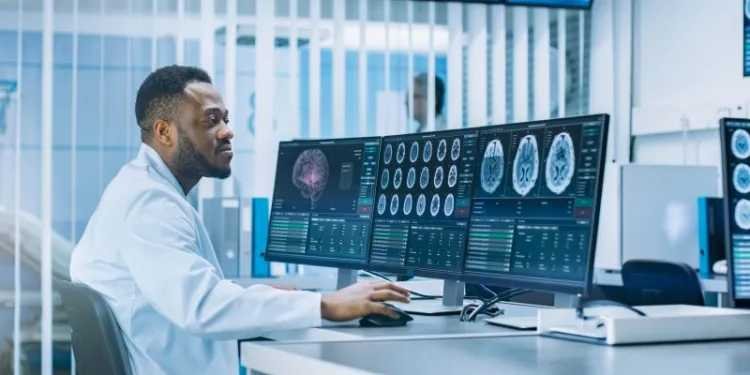 A physician revieweing health data on a set of monitors